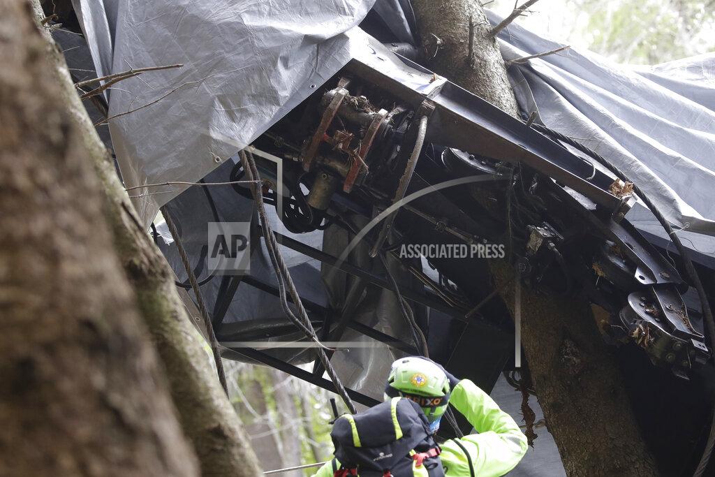 Luca Bruno A rescuer takes a picture of a clamp that was placed on an emergency brake, as search for evidence continues in the wreckage of a cable car after it collapsed near the summit of the Stresa-Mottarone line in the Piedmont region, northern Italy, Wednesday, May 26, 2021. Police have made three arrests in the cable car disaster that killed 14 people after an investigation showed a clamp, placed on the brake as a patchwork repair effort, prevented the brake from engaging after the lead cable snapped. (AP Photo/Luca Bruno)