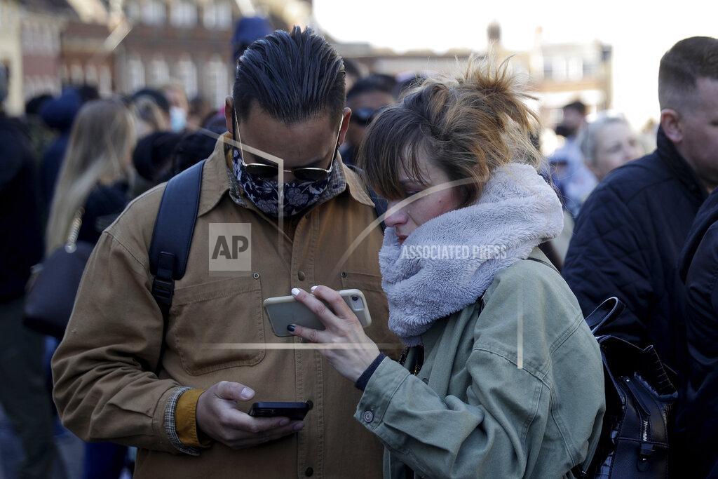Matt Dunham People watch live coverage on a phone outside Windsor Castle during the funeral of Britain's Prince Philip in Windsor, England, Saturday, April 17, 2021. Philip died April 9 at the age of 99 after 73 years of marriage to Britain's Queen Elizabeth II. Coronavirus restrictions mean there will be only 30 mourners for the service, including the widowed queen, her four children and her eight grandchildren. (AP Photo/Matt Dunham)