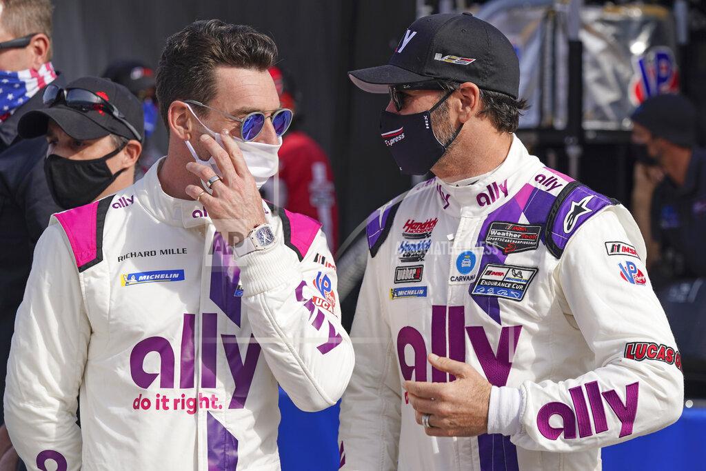John Raoux Teammates Simon Pagenaud, left, of France, and Jimmie Johnson talk on pit road before the start of the Rolex 24 hour auto race at Daytona International Speedway, Saturday, Jan. 30, 2021, in Daytona Beach, Fla. (AP Photo/John Raoux)