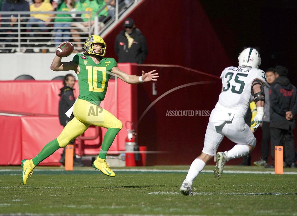 Tony Avelar Oregon quarterback Justin Herbert (10) scrabbles for a first down against Michigan State linebacker Joe Bachie (35) during the first half of the Redbox Bowl NCAA college football game Monday, Dec. 31, 2018, in Santa Clara, Calif. (AP Photo/Tony Avelar)