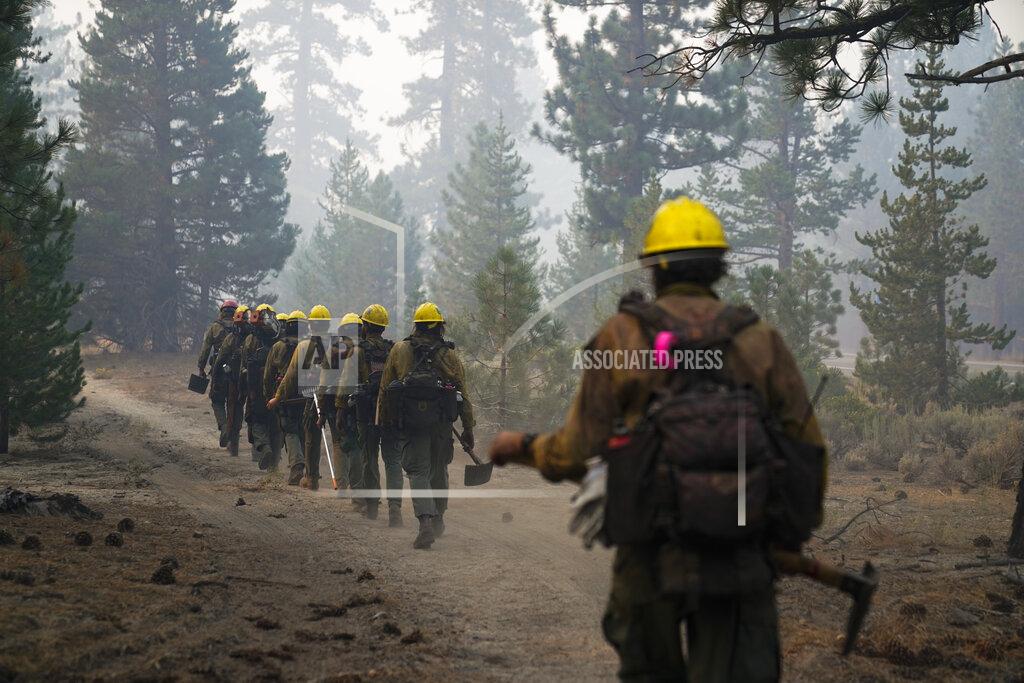 Jae C. Hong A hotshot crew from Tahoe Hotshots hikes along a trail in Meyers, Calif., Friday, Sept. 3, 2021. Fire crews took advantage of decreasing winds to battle a California wildfire near popular Lake Tahoe and were even able to allow some people back to their homes but dry weather and a weekend warming trend meant the battle was far from over. (AP Photo/Jae C. Hong)