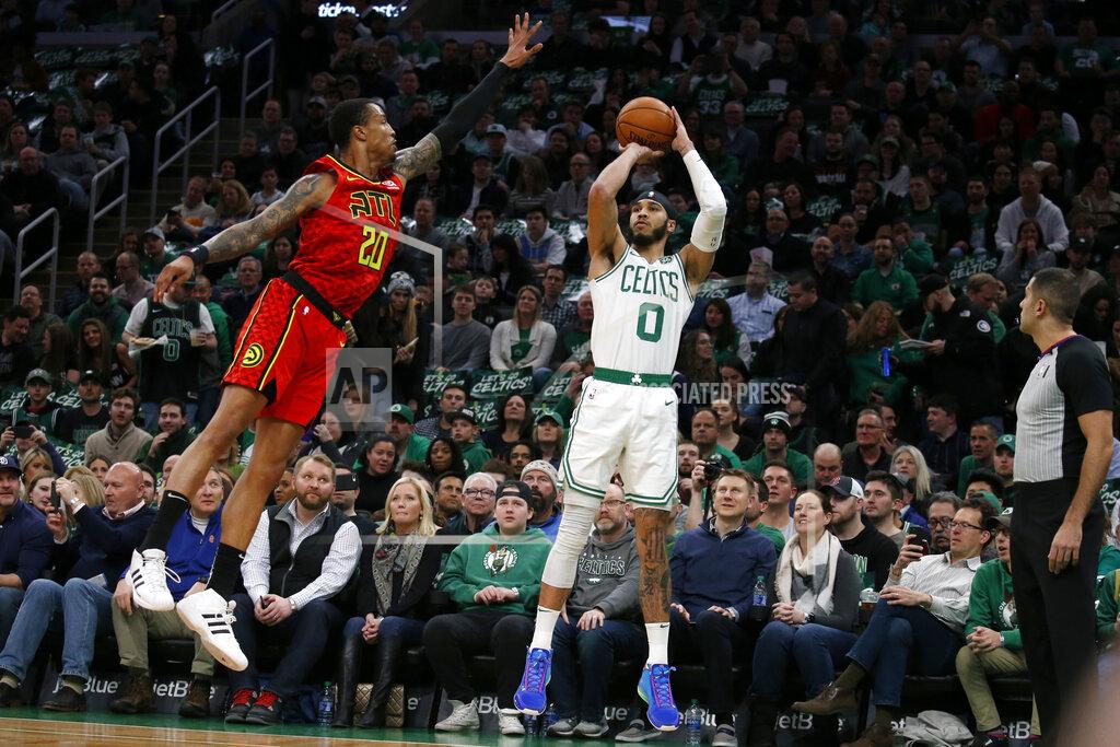 Boston Celtics forward Jayson Tatum (0) shoots a 3-pointer against Atlanta Hawks forward John Collins (20) during the first half of an NBA basketball game Friday, Feb. 7, 2020, in Boston. (AP Photo/Mary Schwalm)