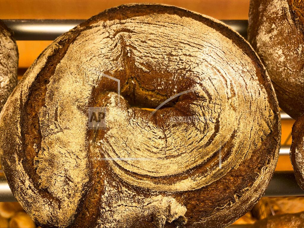 Daniel Niemann A bread loaf that was baked with beer is displayed in the Coelven bakery in Duesseldorf, Germany, Tuesday, March 23, 2021. About 6,000 litres of the renowned copper-colored 'Altbier' of the historic Fuechschen brewery remain unsold and nearing its expiry date. The brewery now works with craft bakers who use the beer to make bread, with about twelve bakeries producing the grain bread and are giving the additional bonus of a bottle of Fuechschen's Altbier free of charge with every loaf.(AP Photo/Daniel Niemann)