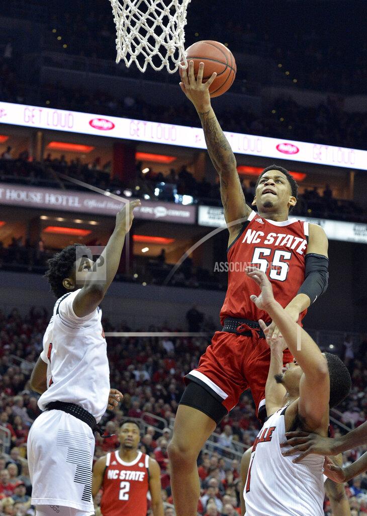 Timothy D. Easley North Carolina State guard Blake Harris (55) goes in for a layup over Louisville guard Darius Perry (2) and guard Christen Cunningham (1) during the first half of an NCAA college basketball game in Louisville, Ky., Thursday, Jan. 24, 2019. (AP Photo/Timothy D. Easley)
