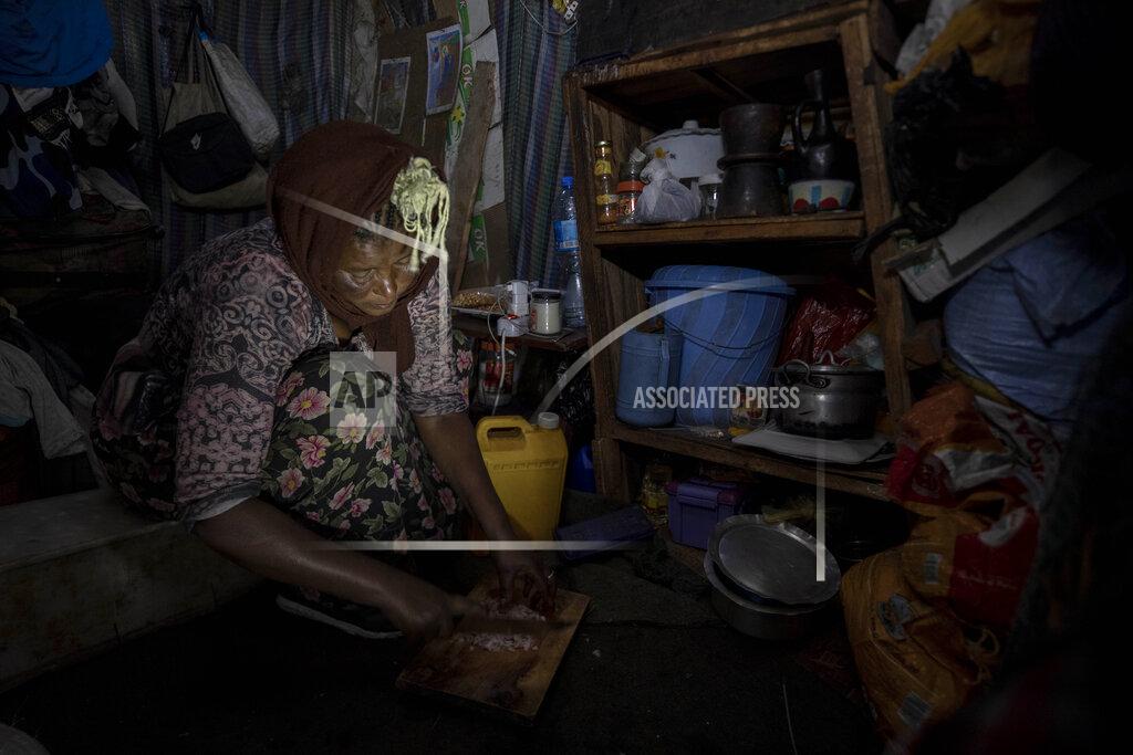 Mother of two Amsale Hailemariam, a domestic worker who lost work because of the coronavirus, prepares food for her family in her small tent in the capital Addis Ababa, Ethiopia on Friday, June 26, 2020. The better-off neighbors who once welcomed her into their homes to cook and clean now turn her away, fearing the virus. “They told me we should avoid contact,” she said. “There was no help I received from them since.” (AP Photo/Mulugeta Ayene)