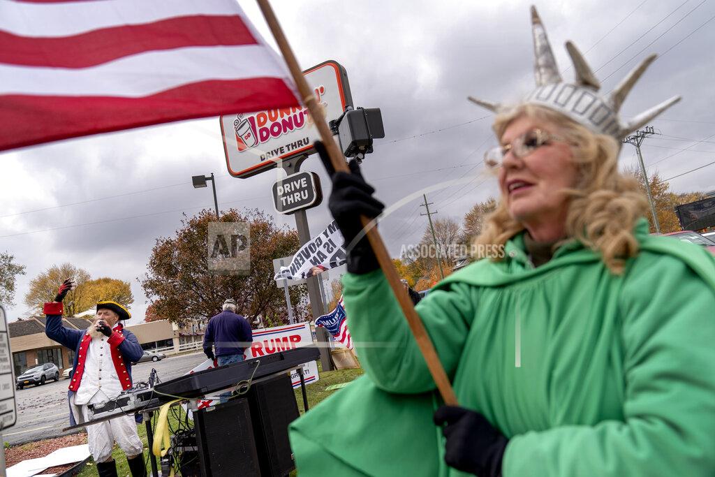 David Goldman Trump supporters Carol Reed, dressed as the Statue of Liberty, right, and Matthew Woods, dressed as a Continental Army soldier, cheer at an intersection during a rally in Mount Clemens, Mich., Thursday, Oct. 29, 2020. About 7 in 10 voters say they are anxious about the election, according to an AP-NORC poll last month. Only a third are excited. Biden supporters were more likely than Trump voters to be nervous, 72% to 61%. (AP Photo/David Goldman)