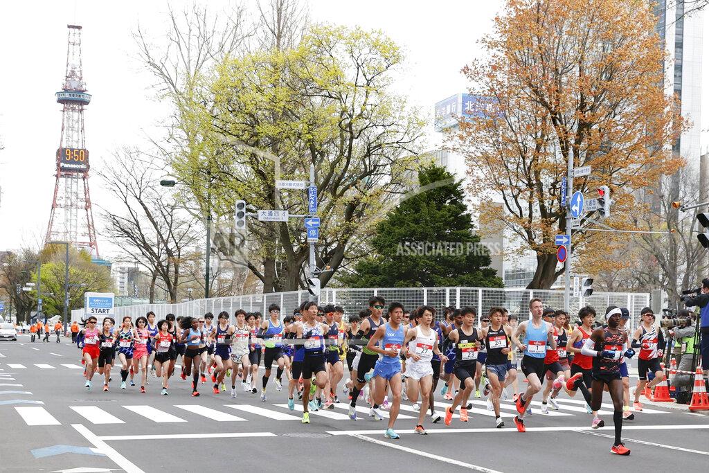 Uncredited Runners start at the Sapporo challenge half-marathon held as a Tokyo 2020 Olympics test event in Sapporo, northern Japan, Wednesday, May 5, 2021. Sapporo TV Tower is seen at left in the background. (Kyodo News via AP)