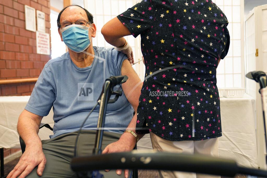 Seth Wenig Marvin Marcus, 79, a resident at the Hebrew Home at Riverdale, receives a COVID-19 booster shot in New York, Monday, Sept. 27, 2021. The deadline for hospital and nursing home workers in New York state to be vaccinated against COVID-19 arrived Monday with the prospect of severe staff shortages fueled by workers getting suspended or fired for refusing to be inoculated. All health care workers in New York state at hospitals and nursing homes are required to be vaccinated with at least one dose of the COVID-19 vaccine by Monday. (AP Photo/Seth Wenig)