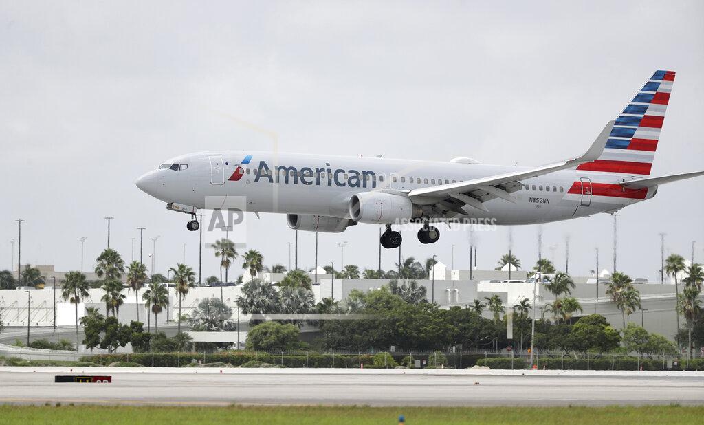 FILE - An American Airlines Boeing 737-823 lands at Miami International Airport, Monday, July 27, 2020, in Miami.American Airlines said Tuesday, Aug. 25 that it will furlough or lay off 19,000 employees in October as it struggles with a sharp downturn in travel because of the pandemic. Flight attendants will bear the heaviest cuts, with 8,100 losing their jobs. (AP Photo/Wilfredo Lee, File)