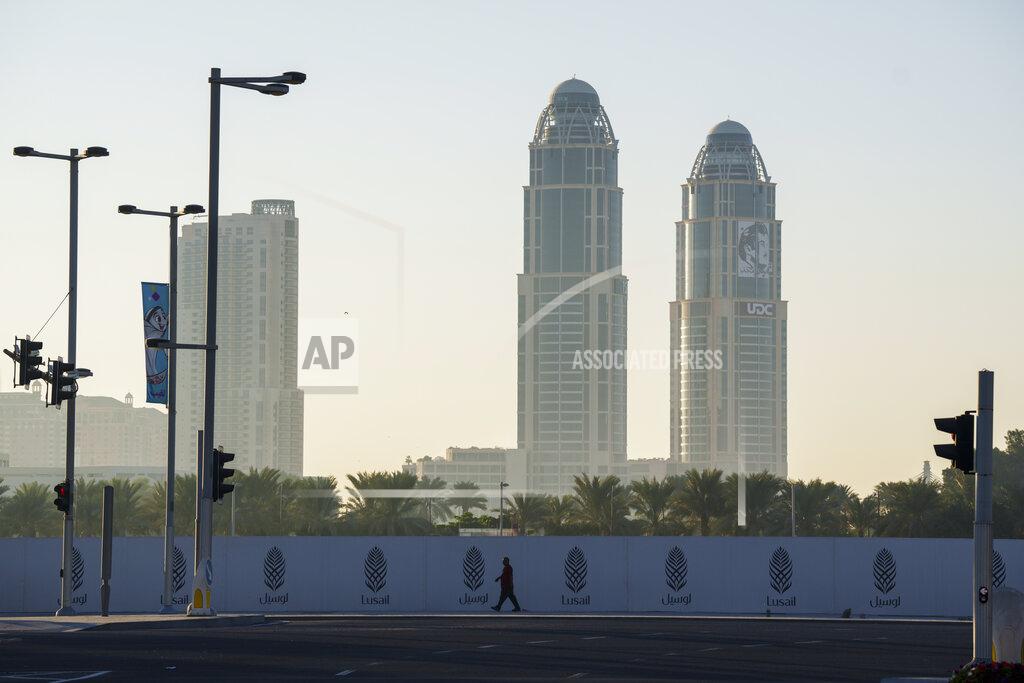 Pavel Golovkin A man walks past a construction site fence in Lusail downtown, Qatar, Thursday, Nov. 24, 2022. (AP Photo/Pavel Golovkin)