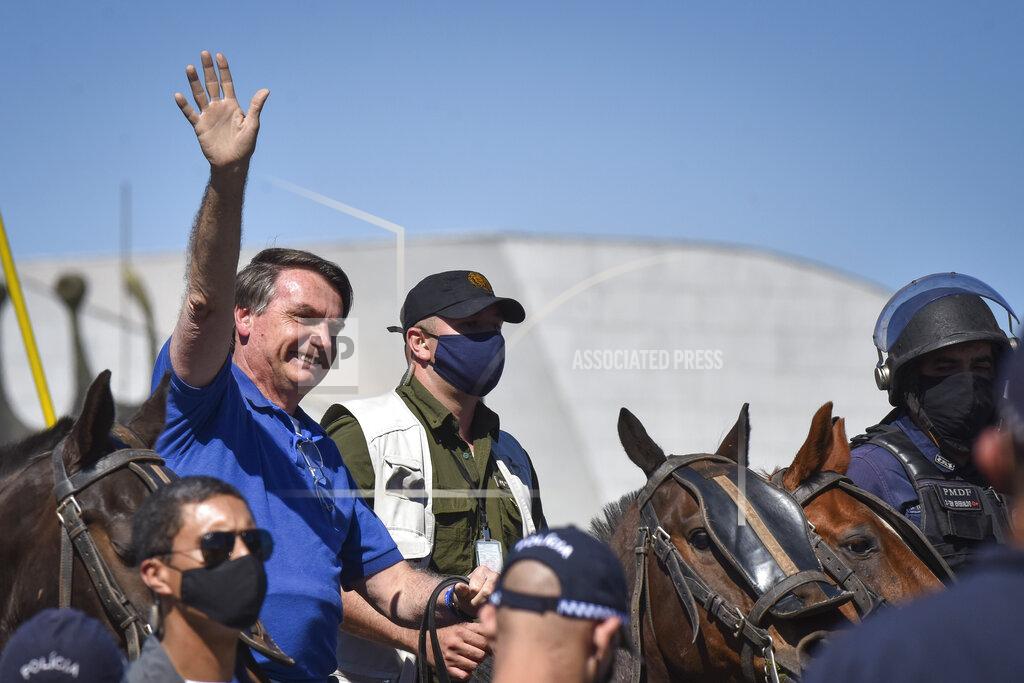 Andre Borges Brazil's President Jair Bolsonaro rides a horse greeting supporters outside the presidential palace in Brasilia, Brazil, Sunday, May 31, 2020. Bolsonaro mounted a horse from police that were guarding supporters of his government gathered outside the Planalto Palace. (AP Photo/Andre Borges)