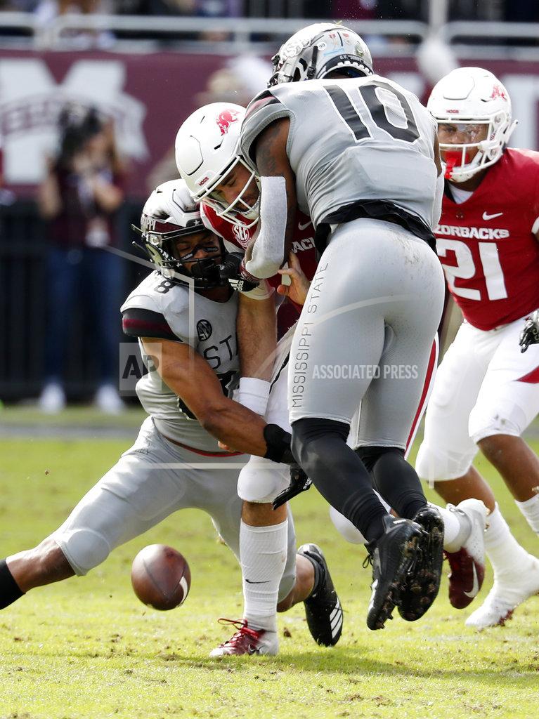 Rogelio V. Solis Arkansas quarterback Ty Storey (4) fumbles the ball after being double-teamed by Arkansas defensive back Jayden Minchew (38) and defensive lineman Randy Ramsey (10) during the first half of an NCAA college football game in Starkville, Miss., Saturday, Nov. 17, 2018. Mississippi State won 52-6. (AP Photo/Rogelio V. Solis)