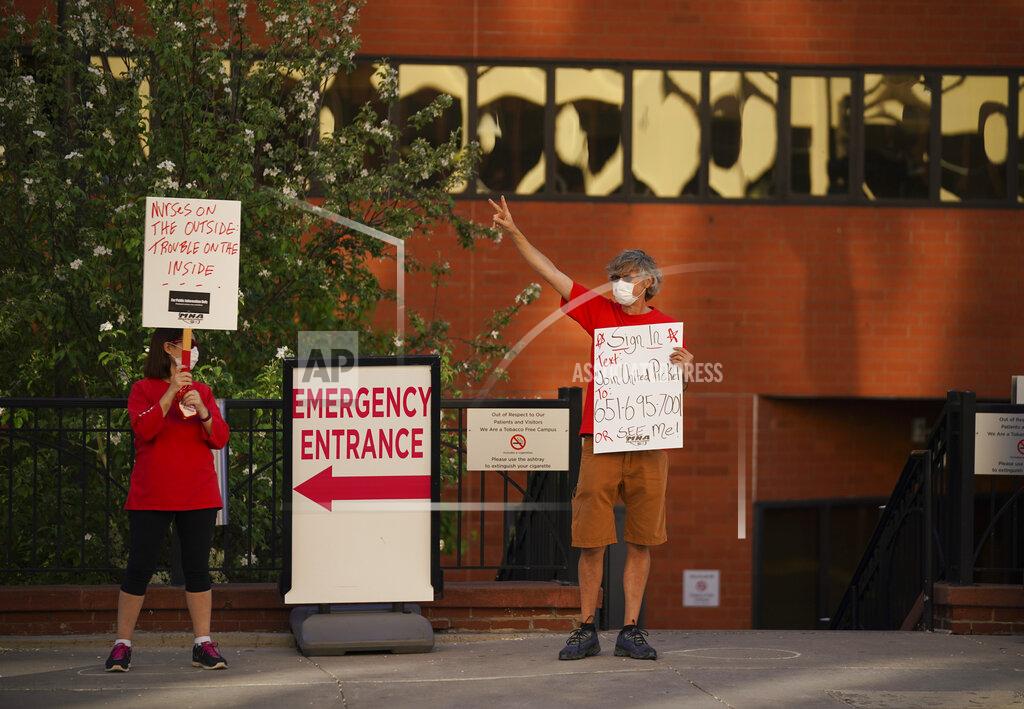 Jeff Wheeler Demonstrators hold signs as the Minnesota Nurses Association held an informational picket Wednesday, May 20, 2020, in St. Paul, Minn., outside United Hospital. Nurse members are asking for a say in worker protections, increased PPE resources with higher safety standards and an end to retaliation against workers who have tried to protect themselves from the COVID-19 virus. After picketing, they marched to the State Capitol to hear speakers. (Jeff Wheeler/Star Tribune via AP)