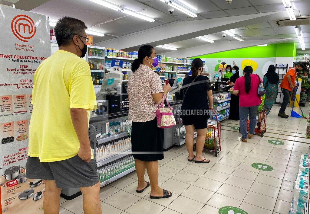 Zen Soo People wear masks and observe social distancing while lining up to pay at a supermarket in Singapore, Friday, May 14, 2021. Singapore further tightened its COVID-19 measures as it sought to control an increase in untraceable coronavirus infections in the city-state. (AP Photo/Zen Soo