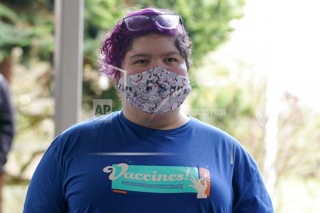 Ted S. Warren Volunteer worker Sarah Sheets wears a T-shirt touting the safety of vaccines as she waits to start her shift, Friday, Feb. 26, 2021, at a mass vaccination clinic at Seattle University in Seattle. As states ramp up vaccination distribution in the fight against the coronavirus, volunteers are needed to do everything from direct traffic to check people in to keep vaccination sites running smoothly. In return for their work, they're often given a shot — including those who are young and healthy and may not have otherwise been able to receive the shot until later in the year. (AP Photo/Ted S. Warren)