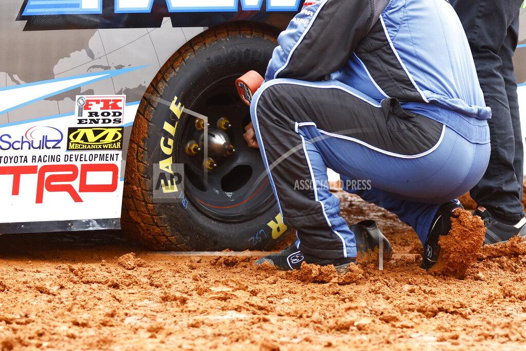 Wade Payne A crew member checks tire pressure on a truck as they prepare to compete in a heat race for a NASCAR Truck Series race on Saturday, March 27, 2021, in Bristol, Tenn. (AP Photo/Wade Payne)