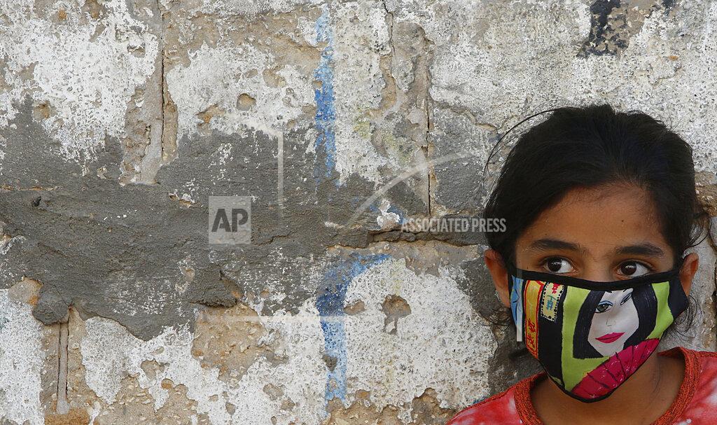 Hatem Moussa FILE - In this Thursday, Aug. 27, 2020 file photo, a Palestinian girl wear a face mask during a lockdown imposed following the discovery of locally transmitted coronavirus cases in the Gaza Strip. The confirmed death toll from the coronavirus has gone over 50,000 in the Middle East as the pandemic continues. That’s according to a count Thursday, Sept. 3, 2020, from The Associated Press, based on official numbers offered by health authorities across the region. (AP Photo/Hatem Moussa, File)
