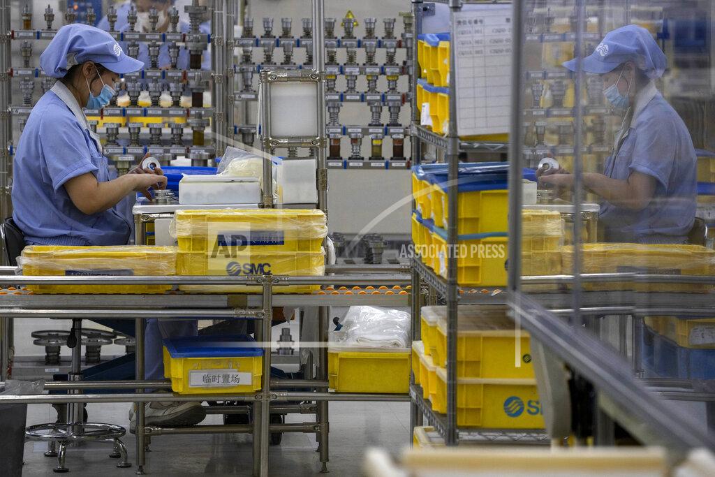 Ng Han Guan In this Wednesday, May 13, 2020, photo, a worker at SMC China, a Japanese joint venture pneumatic engineering company, assembles products at a factory in Beijing. The United States, Japan and France are prodding their companies to rely less on China to make the world’s smartphones, drugs and other products. But even after the coronavirus derailed global trade, few are willing to give up access to its skilled workers, vast market and efficient suppliers by moving factories closer to home. (AP Photo/Ng Han Guan)