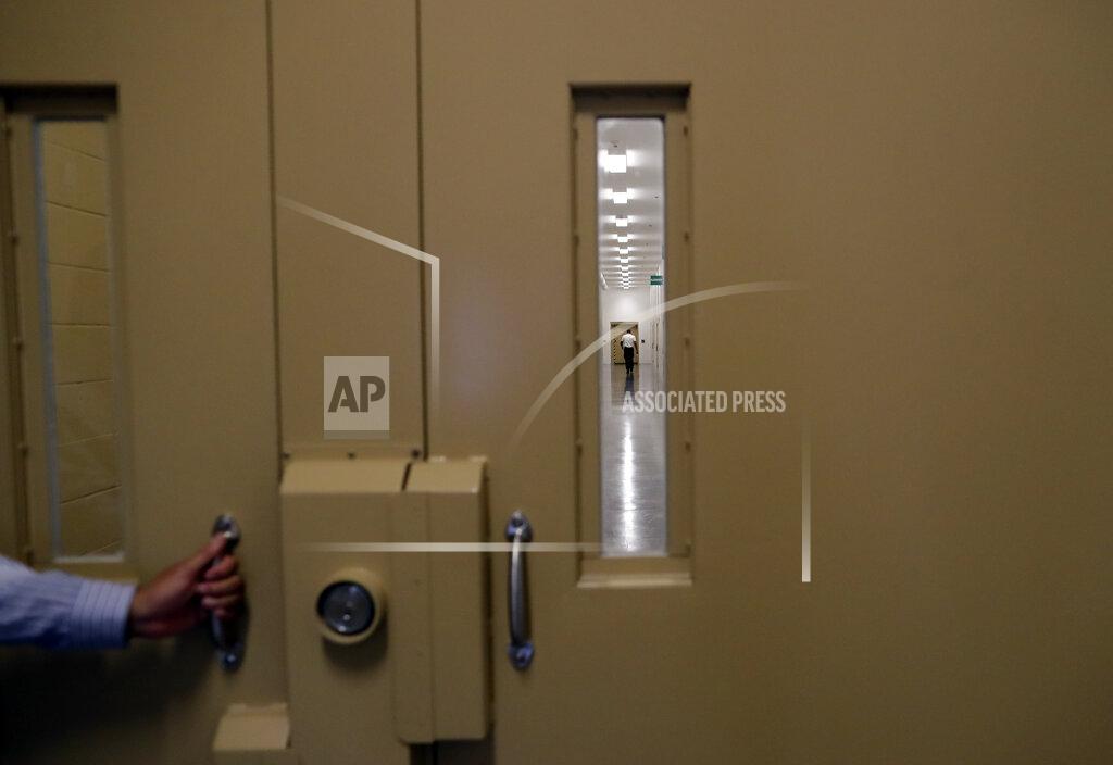 Gregory Bull A man walks in a hallway at the Otay Mesa Detention Center Wednesday, Aug. 23, 2017, in San Diego. The facility was at the center of the first big novel coronavirus outbreak at a U.S. immigration detention center in April 2020. (AP Photo/Gregory Bull)