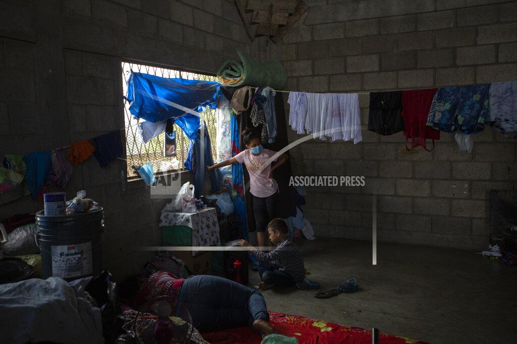 Moises Castillo A family left homeless by last year's hurricanes Eta and Iota live inside an empty warehouse near the Chamelecon neighborhood of San Pedro Sula, Honduras, Tuesday, Jan. 12, 2021. The devastation wrought by November's hurricanes and the economic damage of the COVID-19 pandemic has added to the forces of poverty and gang violence that drive Hondurans to migrate. (AP Photo/Moises Castillo)