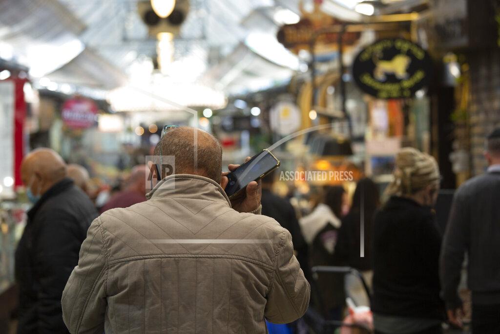 Maya Alleruzzo A man speaks on his mobile phone in the Mahane Yehuda market in Jerusalem, Wednesday, Dec. 23, 2020. In the early days of the pandemic, a panicked Israel began using a mass surveillance tool on its own people, tracking civilians’ mobile phones to halt the spread of the coronavirus. But months later, the tool’s effectiveness is being called into question and critics say its use has come at an immeasurable cost to the country’s democratic principles. (AP Photo/Maya Alleruzzo)