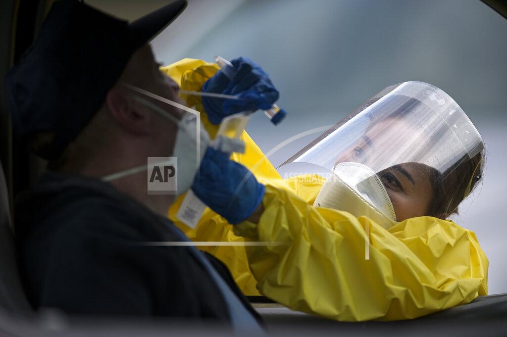 FILE - In this May 23, 2020, file photo Elizabeth Santoro, a medic with the Minnesota Air National Guard 133rd Medical Group, administers a free COVID-19 test at the Minneapolis Armory in Minneapolis. Since the pandemic began, Congress has set aside trillions of dollars to ease the crisis. A joint KHN and Associated Press investigation finds that many communities with big outbreaks have spent little of that federal money on local public health departments for work such as testing and contact tracing. Others, like Minnesota, were slow to do so. (Aaron Lavinsky/Star Tribune via AP, File)