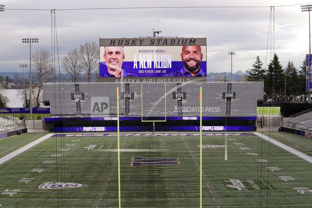 Elaine Thompson Photos of Washington head coach Chris Petersen, left, and defensive coordinator Jimmy Lake are shown on the scoreboard at Husky Stadium after the announcement that Petersen is leaving his position and that Lake is assuming it, Tuesday, Dec. 3, 2019, in Seattle. Petersen unexpectedly resigned at Washington on Monday, a shocking announcement with the Huskies coming off a 7-5 regular season and bound for a sixth straight bowl game under his leadership. Petersen will coach Washington in a bowl game, his final game in charge. (AP Photo/Elaine Thompson)