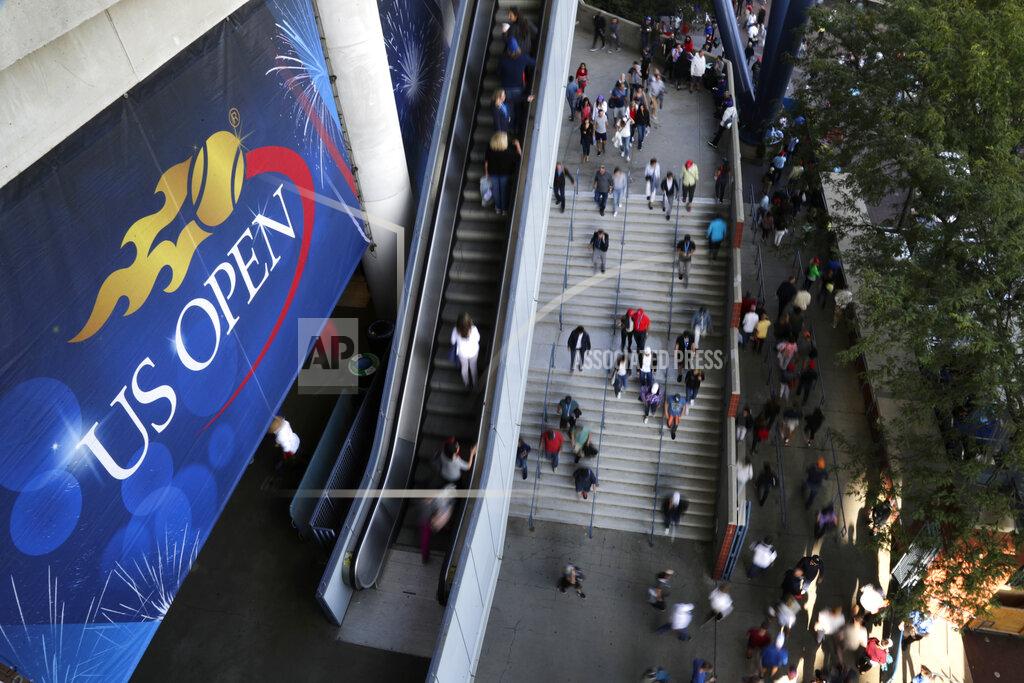 FILE - In this Sept. 3, 2017, file photo, tennis fans move in and out of Arthur Ashe Stadium during the fourth round of the U.S. Open tennis tournament in New York. As coronavirus cases spike in other parts of the country a month before the U.S. Open is supposed to start in New York, the U.S. Tennis Association said Friday, July 31, 2020, it “continues its plans” to hold its marquee event and another tournament beforehand. (AP Photo/Frank Franklin II, File)