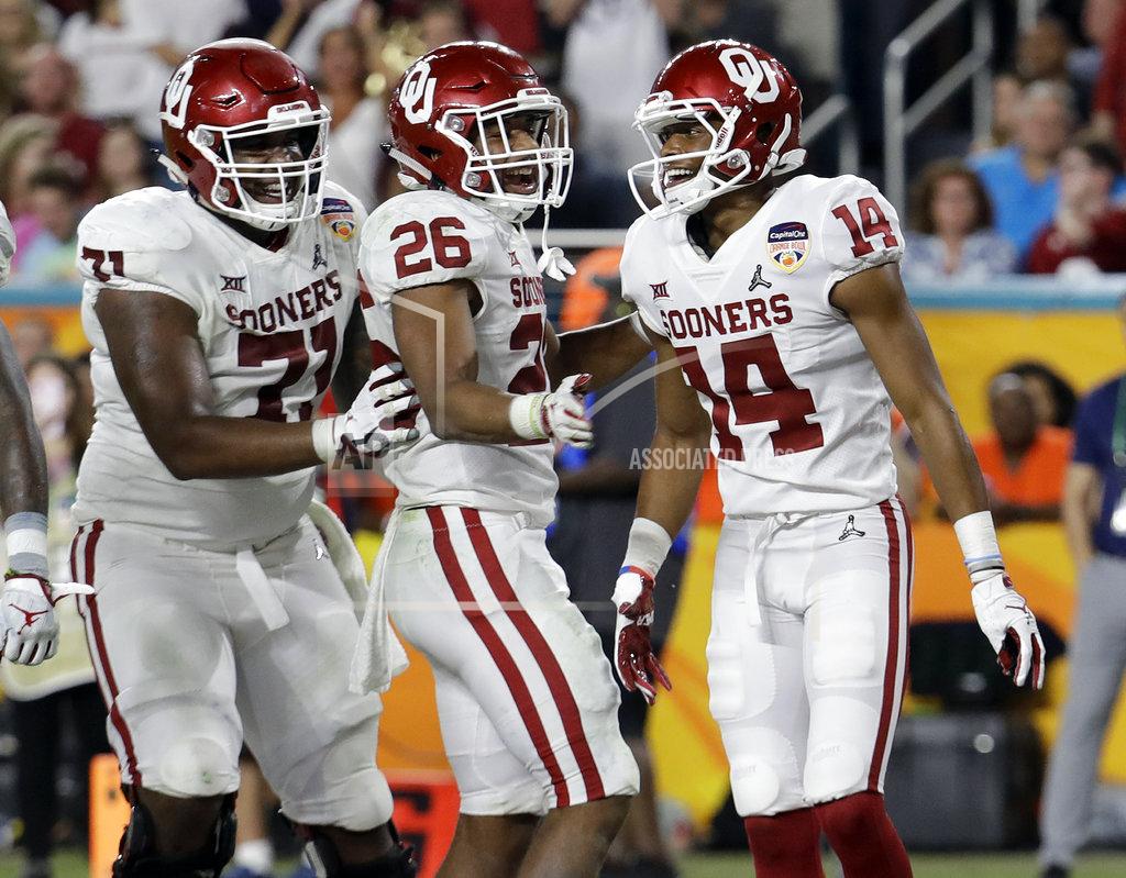 Lynne Sladky Oklahoma offensive lineman Bobby Evans (71) and running back Kennedy Brooks (26) congratulate wide receiver Charleston Rambo (14), after Rambo scored a touchdown, during the second half of the Orange Bowl NCAA college football game against Alabama, Saturday, Dec. 29, 2018, in Miami Gardens, Fla. (AP Photo/Lynne Sladky)