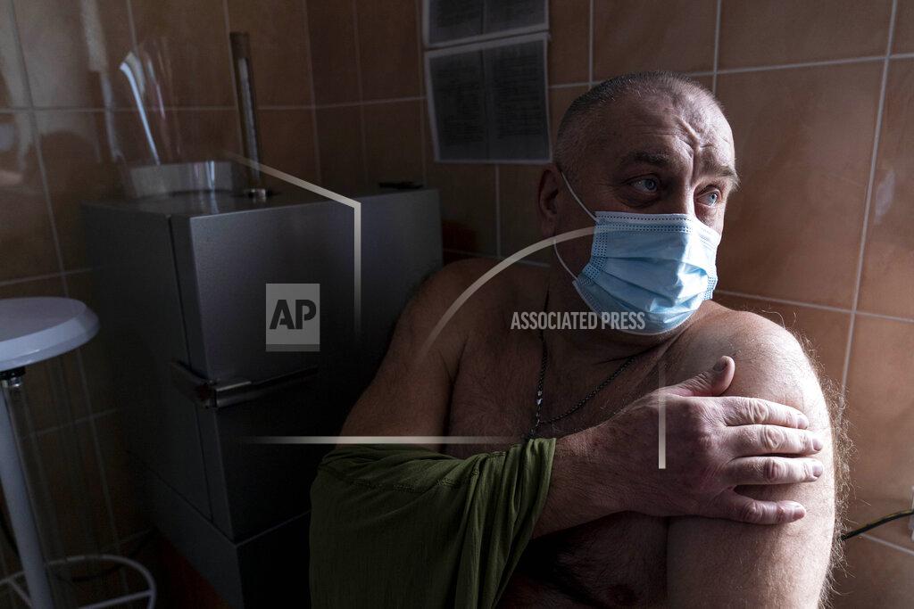 Evgeniy Maloletka A Ukrainian serviceman gets ready to receive a dose of the AstraZeneca COVID-19 vaccine marketed under the name CoviShield at a military base in Kramatorsk, Ukraine, Tuesday, March 2, 2021. Ukraine plans to vaccinate 14.4 million people this year, or about 35% of its 41 million people. (AP Photo/Evgeniy Maloletka)