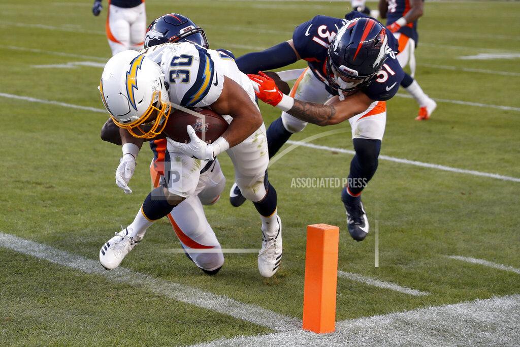 David Zalubowski Los Angeles Chargers running back Austin Ekeler scores ahead of Denver Broncos cornerback Isaac Yiadom and free safety Justin Simmons, right, during the first half of an NFL football game Sunday, Dec. 1, 2019, in Denver. (AP Photo/David Zalubowski)