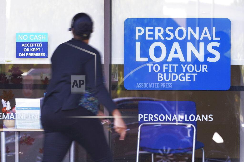 FILE - In this Oct. 1, 2020 file photo, a woman walks past a personal finance loan office in Franklin, Tenn. U.S. consumer borrowing rose by a strong $25.8 billion in March 2021, the second-straight sizable monthly gain. The number released Friday, May 7 by the Federal Reserve represents another indication that the U.S. economic recovery is gaining steam. (AP Photo/Mark Humphrey, File)