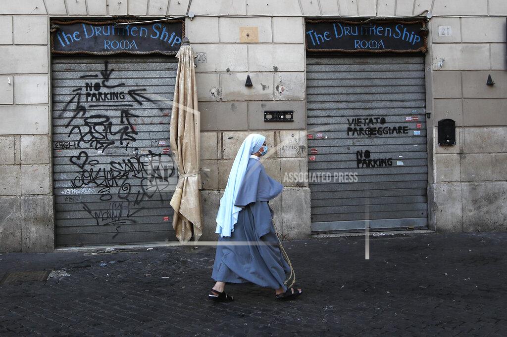 Alessandra Tarantino A nun wearing a face mask to curb the spread of COVID-19, walks past a closed shop in downtown Rome, Monday, March 15, 2021. Half of Italy's regions have gone into the strictest form of lockdown in a bid to curb the latest spike in coronavirus infections that have brought COVID-19 hospital admissions beyond manageable thresholds. (AP Photo/Alessandra Tarantino)