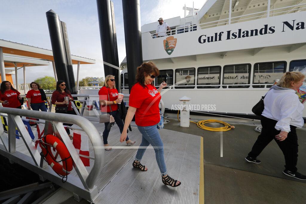Gerald Herbert In this March 13, 2020, photo, people board the "Turtle Runner" ferryboat, which transports people from downtown to the beaches, and was funded with money from BP due to the Deepwater Horizon oil spill, in Pensacola, Fla. As oil spewed into the Gulf of Mexico from a blown-out BP well in 2010, residents wondered whether their home would ever be the same. But this much is clear: From a baseball stadium and beaches, to roads and a seashore ferry, with island and coastal restoration sprinkled throughout, life along the Gulf Coast is forever changed. (AP Photo/Gerald Herbert)