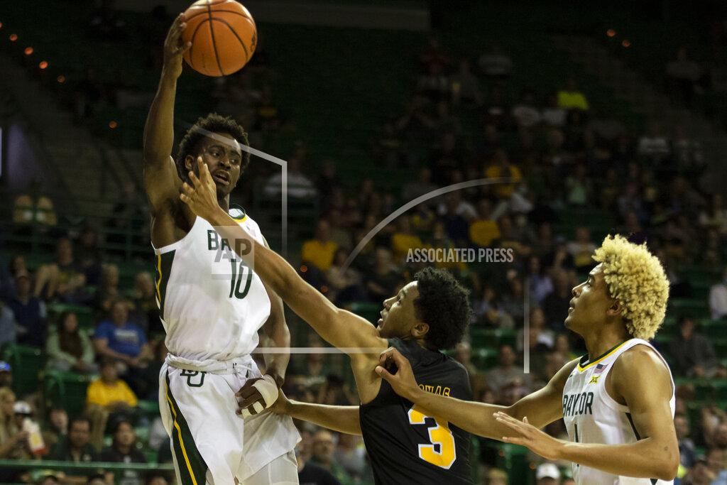 Emil Lippe Baylor guard Adam Flagler (10) passes the ball over Arkansas-Pine Bluff guard Jaylan Thomas (3) to Baylor Bears forward Jeremy Sochan (1) in the first half of an NCAA college basketball game in Waco, Texas, Saturday, Dec. 4, 2021. (AP Photo/Emil Lippe)