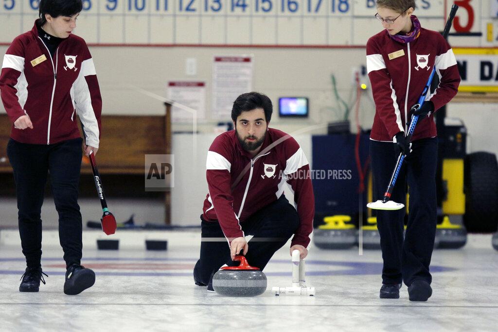 Bill Sikes Harvard's Neekon Vafa, center, delivers a rock during the college curling national championship, Friday, March 8, 2019, in Wayland, Mass. (AP Photo/Bill Sikes)