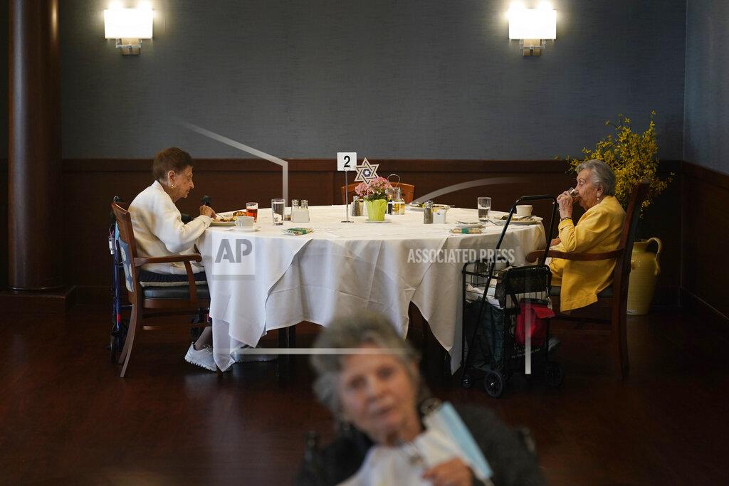 Seth Wenig FILE - Ceil Tuder, left, and Olga Rosenson, right, eat together for one of the first times since the start of the pandemic at RiverWalk, an independent senior housing facility, Thursday, April 1, 202, in New York. Since the start of the pandemic, residents had been dining in their rooms. Only recently have they began to use the dining hall again. A focus on the elderly at the start of the nation's vaccination campaign helped protect nursing homes that were ravaged at the height of the U.S. coronavirus outbreak, but they are far from in the clear. New outbreaks, often traced to infected staff members, are still occurring in long-term care centers across the country, causing continued havoc for visitation policies. (AP Photo/Seth Wenig, File)
