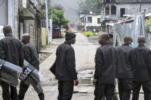 Riot police stand on a road in the Coulee district of Moroni, Comoros, on Thursday Jan. 18, 2024. One person has been killed and at least six injured after a second day of violent unrest in the Indian Ocean island nation of Comoros, a health official said. The protests came after incumbent President Azali Assoumani was declared the winner in an election over the weekend that was denounced by the country's opposition parties as fraudulent. (AP Photo/Nazir Nazi)