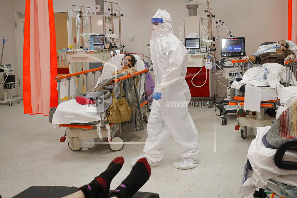Andreea Alexandru Medical staff attend to patients in the emergency room, turned into a CODIV-19 unit due the high number of cases, at the Bagdasar-Arseni hospital in Bucharest, Romania, Tuesday, Oct. 12, 2021. Romania reported on Tuesday nearly 17,000 new COVID-19 infections and 442 deaths, the highest number of coronavirus infections and deaths in a day since the pandemic started, as the nation's health care system struggles to cope with an acute surge of new cases.(AP Photo/Andreea Alexandru)