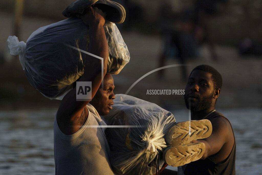 Fernando Llano FILE - In the Sept. 22, 2021, file photo, migrants, many from Haiti, wade across the Rio Grande from Del Rio, Texas with their belongings to return to Ciudad Acuna, Mexico to avoid possible deportation from the U.S. The Border Patrol's treatment of Haitian migrants, they say, is just the latest in a long history of discriminatory U.S. policies and of indignities faced by Black people, sparking new anger among Haitian Americans, Black immigrant advocates and civil rights leaders.(AP Photo/Fernando Llano, File)