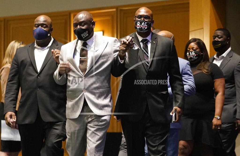 David Joles Floyd family attorney Ben Crump, center, walks in with George Floyd's brothers Philonise Floyd, right, and Rodney Floyd, left, before they announced a $27 million civil lawsuit settlement between the Floyd family and the City of Minneapolis Friday, March 12, 2021, in Minneapolis. (David Joles/Star Tribune via AP)