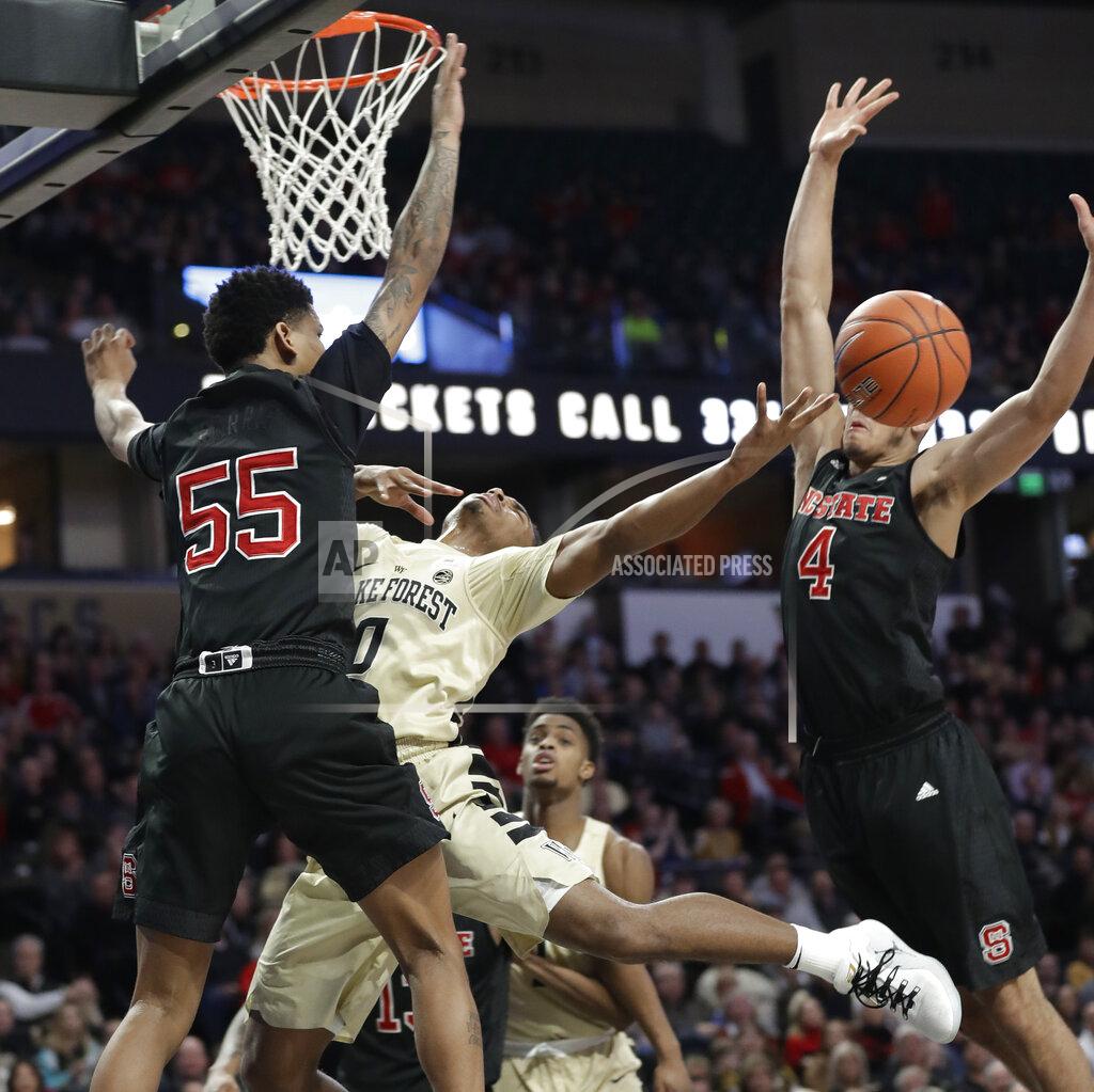 Chuck Burton Wake Forest's Brandon Childress (0) is fouled as he drives between North Carolina State's Blake Harris (55) and Jericole Hellems (4) during the first half of an NCAA college basketball game in Winston-Salem, N.C., Tuesday, Jan. 15, 2019. (AP Photo/Chuck Burton)