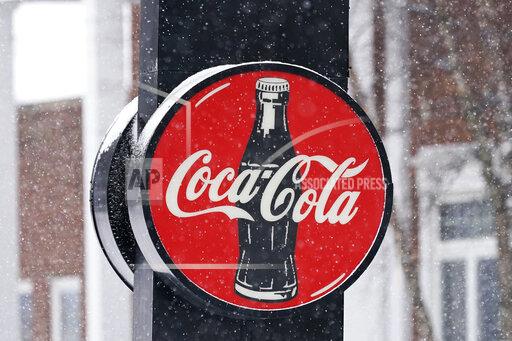 A Coca-Cola sign hangs outside a Coca-Cola distributor, Tuesday, Feb. 9, 2021, in Bedford, Ohio. Coca-Cola Co. is getting its fizz back. The Atlanta beverage company said Wednesday, Oct. 27, 2021, its revenue jumped 16% to $10 billion in the third quarter as stadiums, movie theaters and other venues reopened around the world. (AP Photo/Tony Dejak)