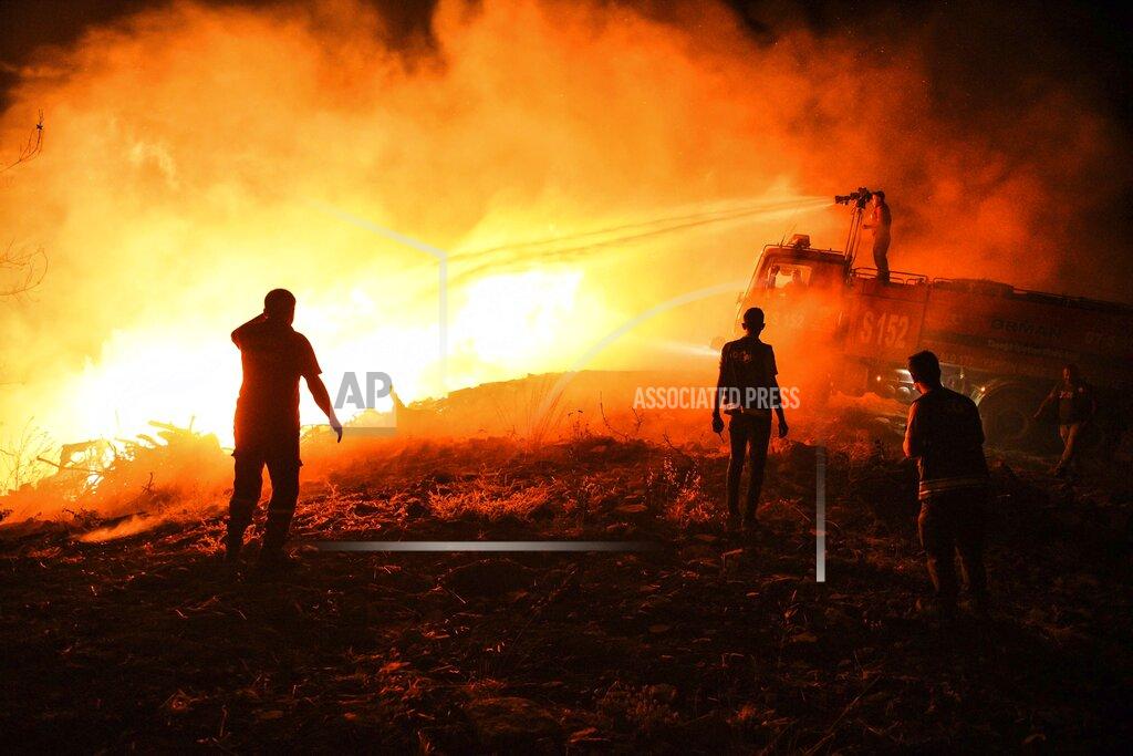 Uncredited Firefighters and Local villagers try to get the fire under control in Kirli village near the town of Manavgat, in Antalya province, Turkey, early Friday July 30, 2021. The fire that continued all night could not be brought under control and people living in the village started to evacuate. Wildfires are common in Turkey's Mediterranean and Aegean regions during the arid summer months, although some previous forest fires have been blamed on arson. (AP Photo)