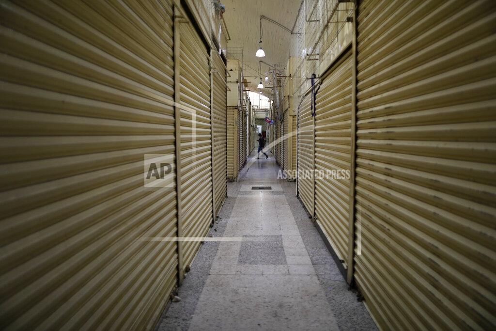 Rebecca Blackwell A shopper walks past a row of closed stalls, inside a partially-open market in the Xochimilco district of Mexico City, Thursday, May 7, 2020. Health authorities concede that the real number of COVID-19 infections in the densely populated capital is many times higher than the official count, and authorities and experts agree that the worst is yet to come. (AP Photo/Rebecca Blackwell)