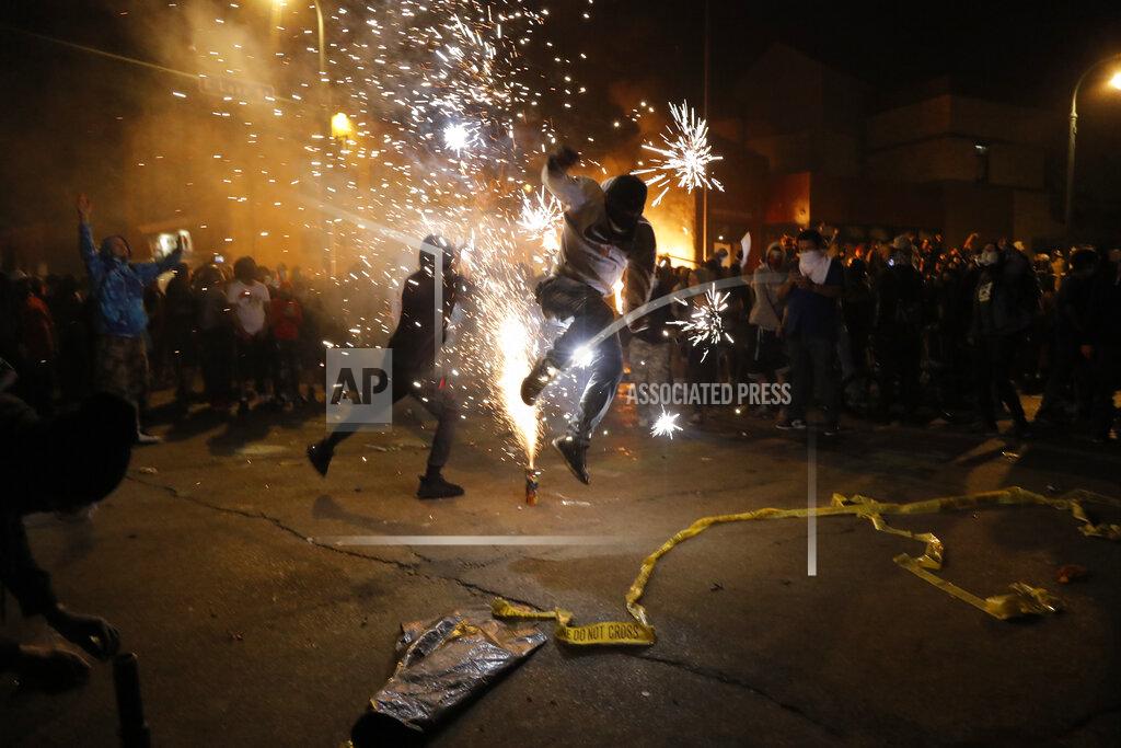 Julio Cortez Protesters set off fireworks as a fire burns at the Minneapolis police 3rd Precinct building Thursday, May 28, 2020, in Minneapolis. Violent protests over the death of George Floyd, a black man who died in police custody Monday, broke out in Minneapolis for a third straight night. (AP Photo/Julio Cortez)