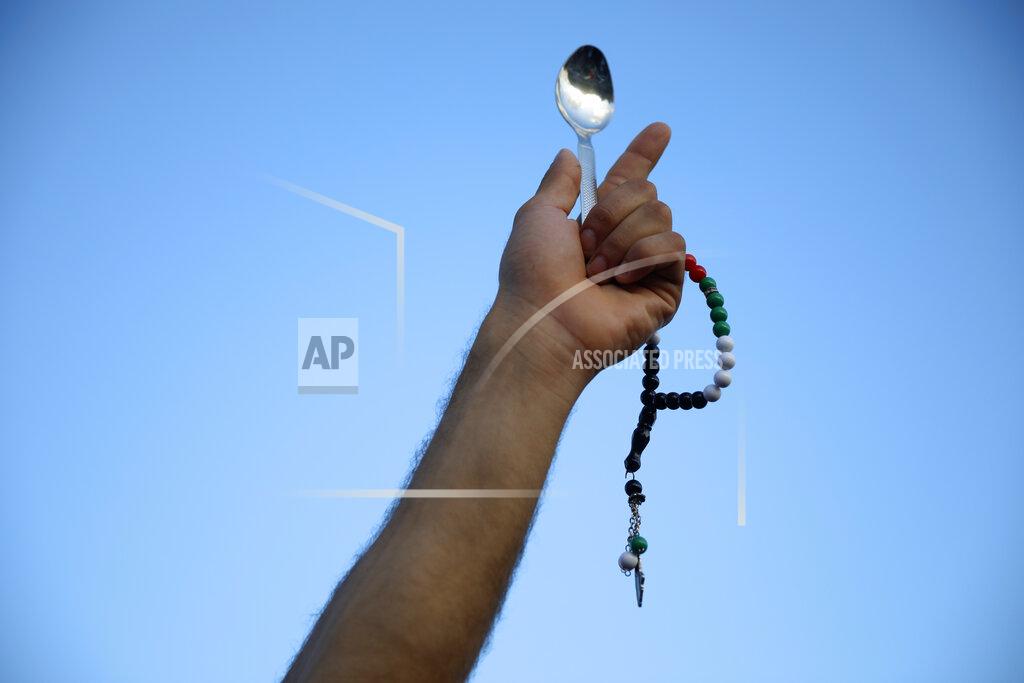 Ariel Schalit A protester holds a spoon, which has become a symbol celebrating the six Palestinian prisoners who recently tunneled out of Gilboa Prison, in Umm el-Fahm, Israel, Friday, Sept. 10, 2021. (AP Photo/Ariel Schalit)