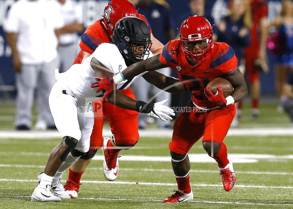 Rick Scuteri Arizona running back J.J. Taylor (21) stiff arms an Oregon defender in the first half during an NCAA college football game, Saturday, Oct. 27, 2018, in Tucson, Ariz. (AP Photo/Rick Scuteri)