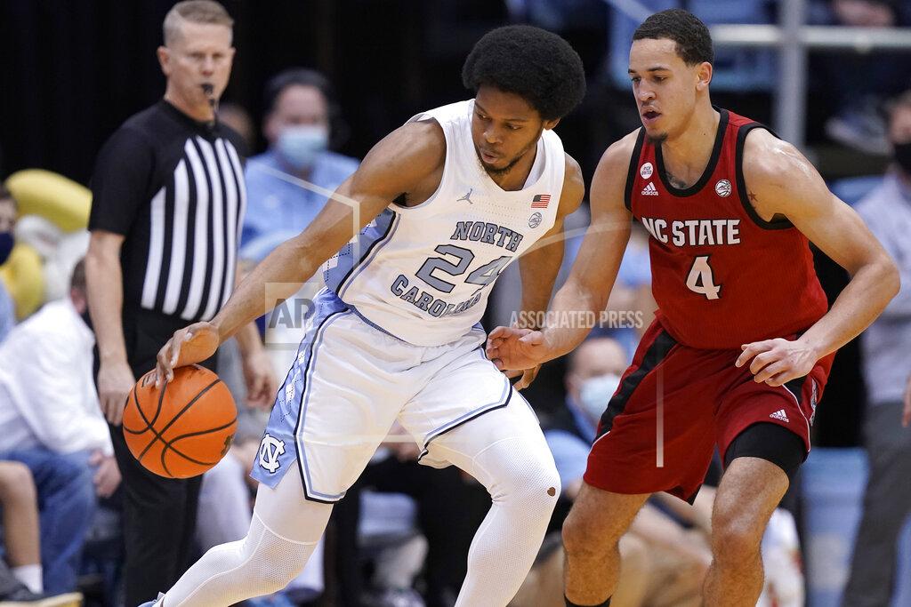 Gerry Broome North Carolina State forward Jericole Hellems (4) defends against North Carolina guard Kerwin Walton (24) during the second half of an NCAA college basketball game in Chapel Hill, N.C., Saturday, Jan. 29, 2022. (AP Photo/Gerry Broome)
