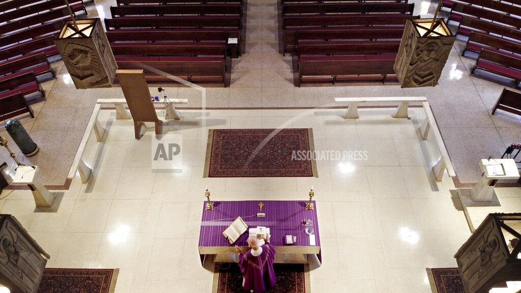 David Goldman The Rev. Peter Gower holds his daily Mass before empty pews at Our Lady of Grace Catholic Church, Sunday, March 29, 2020, in Johnston, R.I. "I've been able to be there to support them through all these things in their life. I feel connected to the people and I do look out and I do see them," said the Rev. Gower who continues to celebrate his daily Mass even though the church is closed to gatherings due the coronavirus. "I have all that in my heart and my mind so there'a unity that's present whether they're there or not." (AP Photo/David Goldman)